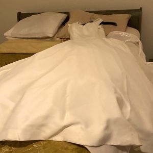 Ballgown with modern, box pleat on Full A line skirt. buttons to end of train.